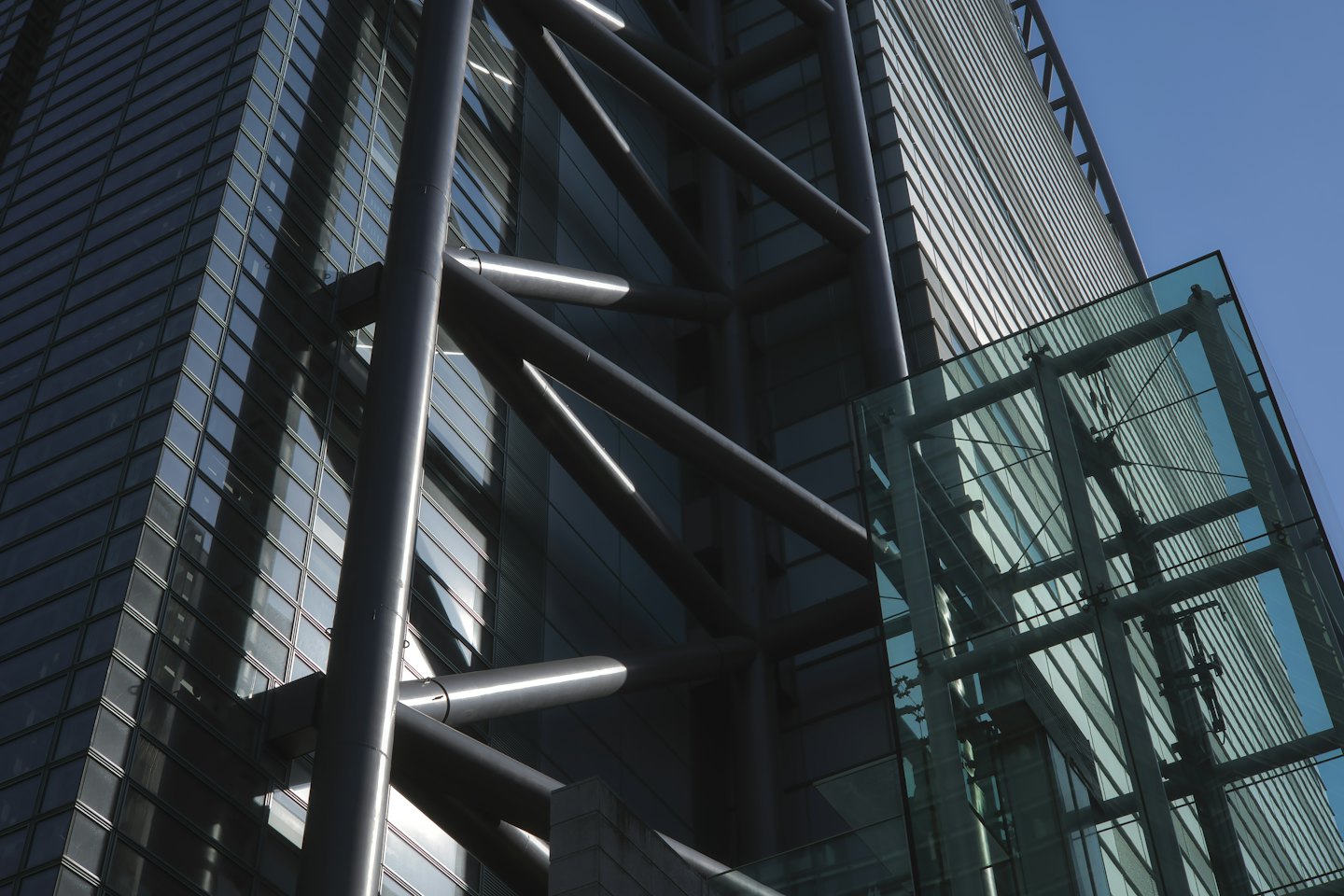 Modern skyscraper with glass facade and diagonal support beams.
