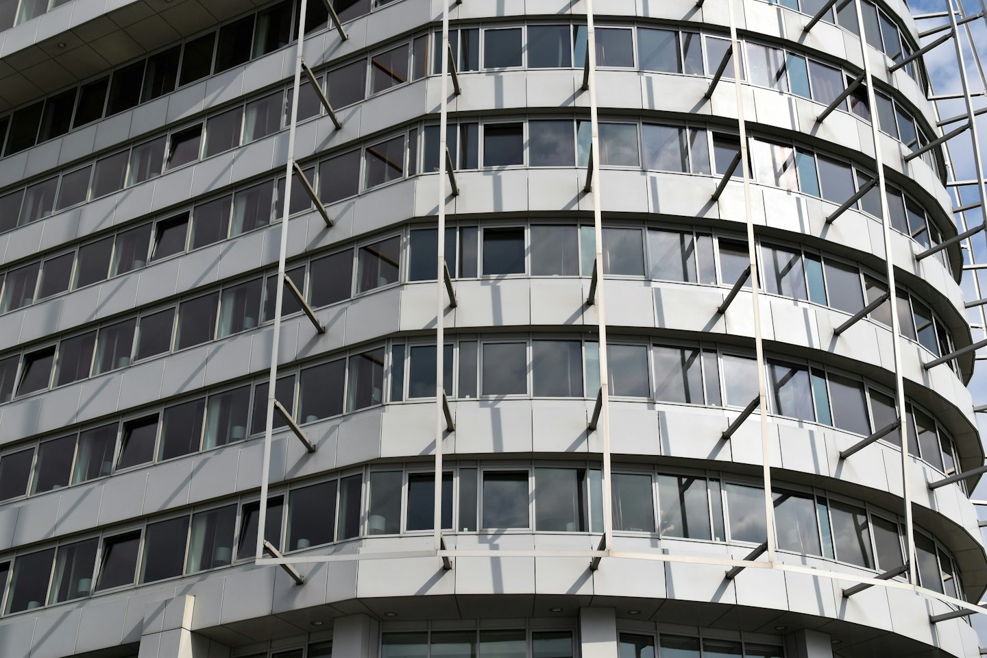 Modern office building facade with dark glass windows and grey panels.