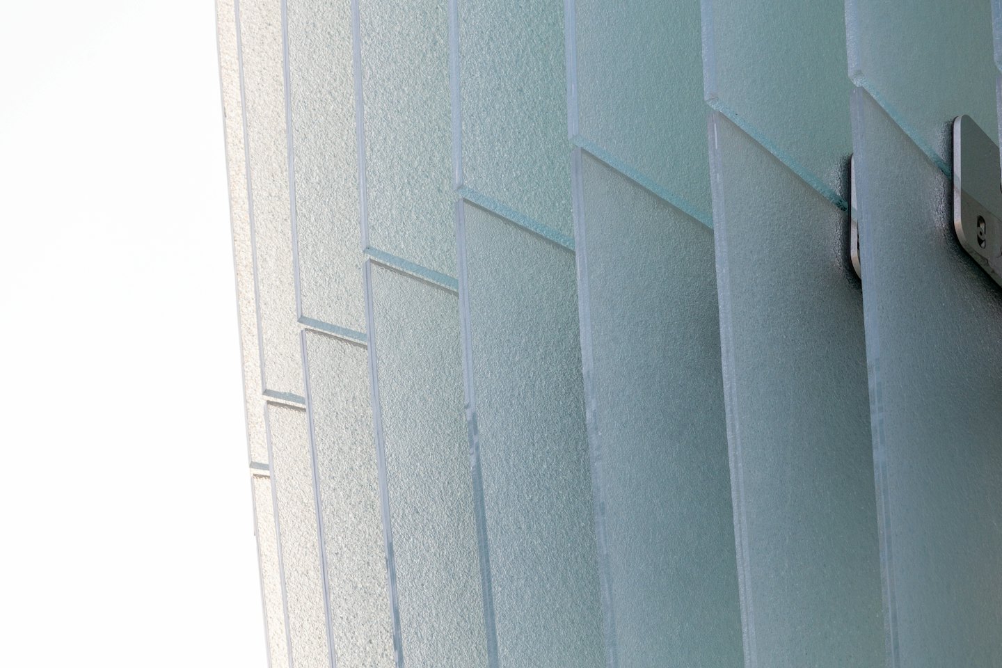 Textured glass panels connected by metal fasteners.