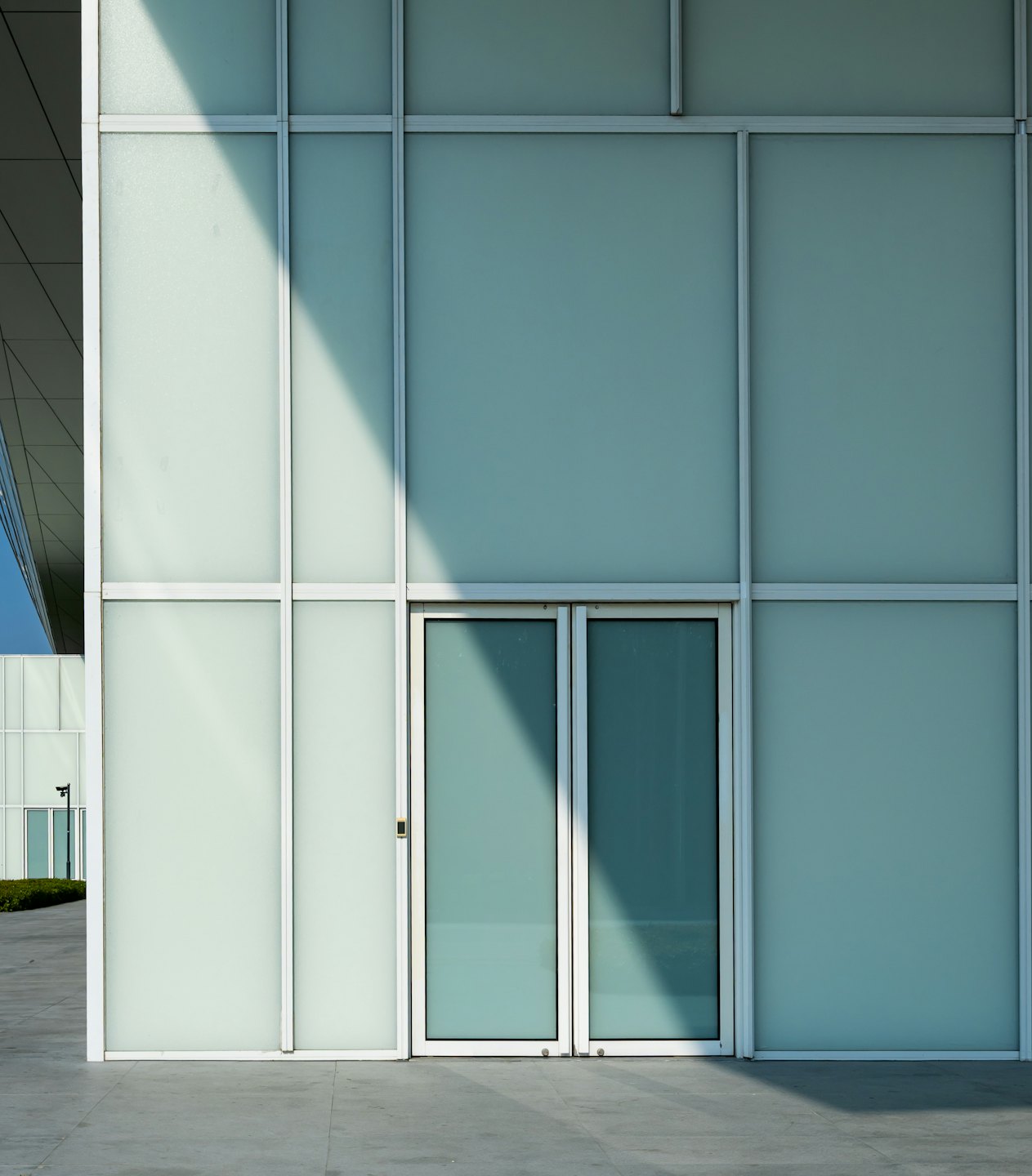 Modern building entrance with frosted glass and white frames.